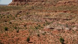 5.5K aerial stock footage of flying low over butte, revealing distant buttes in Monument Valley, Utah, Arizona Aerial Stock Footage | AX135_087E