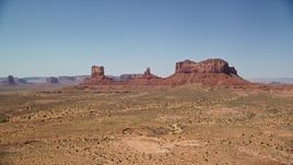 5.5K aerial stock footage of an approach to buttes across a desert valley, Monument Valley, Utah, Arizona Aerial Stock Footage | AX135_105E