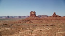 5.5K aerial stock footage of flying by buttes with a view of the desert valley, Monument Valley, Utah, Arizona Aerial Stock Footage | AX135_108E