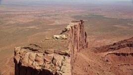 5.5K aerial stock footage of flying over Meridian Butte, pan to reveal Rooster Rock butte, Monument Valley, Utah, Arizona Aerial Stock Footage | AX135_146E