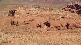 5.5K aerial stock footage of flying by caves, rock formations in Monument Valley, Utah, Arizona Aerial Stock Footage | AX135_179