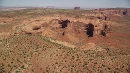 5.5K aerial stock footage of a view of Mitchell Mesa in hazy desert valley, Monument Valley, Utah, Arizona Aerial Stock Footage | AX135_186E