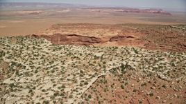 5.5K aerial stock footage of flying over Mitchell Mesa, approaching a wide desert valley, Monument Valley, Utah, Arizona Aerial Stock Footage | AX135_188E