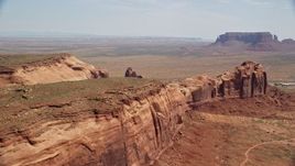 5.5K aerial stock footage of a wide view of Monument Valley buttes seen from Rock Door Mesa, Navajo Nation Reservation, Utah, Arizona Aerial Stock Footage | AX135_198E