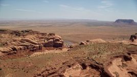 5.5K aerial stock footage of passing Goulding between Oljeto Mesa and Rock Door Mesa, Navajo Nation Reservation, Utah, Arizona Aerial Stock Footage | AX135_200E