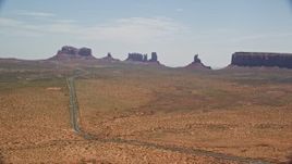 5.5K aerial stock footage of flying by Highway 163 leading to buttes in Monument Valley Arizona, Utah Aerial Stock Footage | AX136_002E