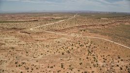5.5K aerial stock footage of approaching rural homes beside Douglas Mesa Road, Navajo Nation Reservation, Utah, Arizona Aerial Stock Footage | AX136_049E