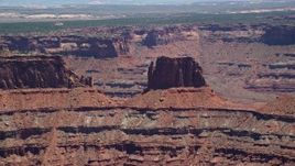 5.5K aerial stock footage of flying by desert butte atop canyon wall, Canyonlands National Park, Utah Aerial Stock Footage | AX136_263