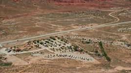 5.5K aerial stock footage of flying by Archview RV & Resort Campground by Highway 191, Moab, Utah Aerial Stock Footage | AX136_288