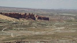 5.5K aerial stock footage of passing by Cotter Mine Road and desert rock formations, Moab, Utah Aerial Stock Footage | AX136_291E