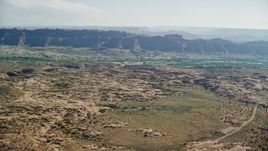 5.5K aerial stock footage approach small desert town from rock formations, Sand Flats Recreation Area, Moab, Utah Aerial Stock Footage | AX138_036E
