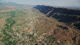5.5K aerial stock footage of a highway running through a small desert town, Moab, Utah Aerial Stock Footage | AX138_041E