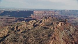 5.5K aerial stock footage of passing by rock formations overlooking a canyon and mesas, Moab, Utah Aerial Stock Footage | AX138_053E