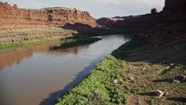 5.5K aerial stock footage fly low over shaded river through Goose Neck in Meander Canyon, Canyonlands National Park, Utah Aerial Stock Footage | AX138_095