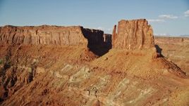 5.5K aerial stock footage fly between cliff and United Nations Tablet butte, reveal Lockhart Canyon, Moab, Utah Aerial Stock Footage | AX138_179E