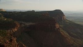 5.5K aerial stock footage of flying by a mesa, overlooking a hazy canyon, Moab, Utah Aerial Stock Footage | AX138_251
