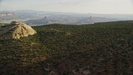 5.5K aerial stock footage of flying by rock formation, tilt to desert plants, Moab, Utah Aerial Stock Footage | AX138_255