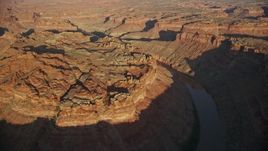 5.5K aerial stock footage of passing The Loop West in Meander Canyon and Colorado River, Canyonlands National Park, Utah, sunset Aerial Stock Footage | AX138_299