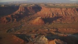 5.5K aerial stock footage of flying by butte near box canyon in Lockhart Canyon, Moab, Utah, sunset Aerial Stock Footage | AX138_345E