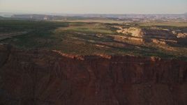 5.5K aerial stock footage approach and fly over dirt road near rock formations on Hatch Point, Moab, Utah, sunset Aerial Stock Footage | AX138_350E
