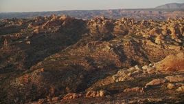 5.5K aerial stock footage of an approach to desert rock formations, valley in distance, Moab, Utah, sunset Aerial Stock Footage | AX138_372E