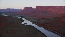 5.5K aerial stock footage video follow Colorado River and State Route 128, mesas in background, Moab, Utah, sunset Aerial Stock Footage | AX138_403E