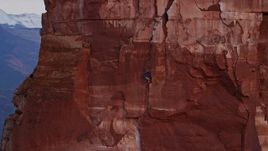 5.5K aerial stock footage of a rock climber on the side of Castleton Tower, Moab, Utah, sunset Aerial Stock Footage | AX138_422