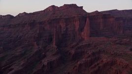 5.5K aerial stock footage of flying by Cottontail Tower, Echo Tower, The Titan at base of mesa in Fisher Towers, Utah, sunset Aerial Stock Footage | AX138_432E