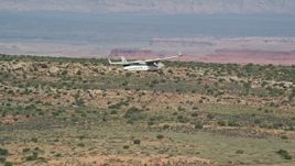 5.5K aerial stock footage track a Tecnam P2006T flying over desert valley, Grand County, Utah Aerial Stock Footage | AX139_033E