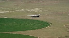 5.5K aerial stock footage video of a Cessna airplane over circular crop field, Green River, Utah Aerial Stock Footage | AX139_092E