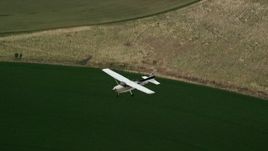 5.5K aerial stock footage track a Cessna over circular crop fields from above, Green River, Utah Aerial Stock Footage | AX139_100