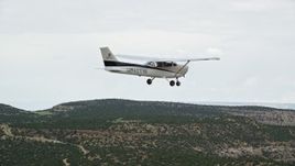 5.5K aerial stock footage reveal and then track a Cessna over desert, Emery County, Utah Aerial Stock Footage | AX139_116E