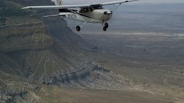 5.5K aerial stock footage of a Cessna flying high above desert, near mountains, Emery County, Utah Aerial Stock Footage | AX139_123E