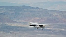 5.5K aerial stock footage of Cessna airplane flying high above desert, partly cloudy, Emery County, Utah Aerial Stock Footage | AX139_126E