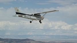 5.5K aerial stock footage of flying beside a Cessna high above desert, partly cloudy skies, Emery County, Utah Aerial Stock Footage | AX139_137E