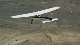 5.5K aerial stock footage track a Cessna aircraft flying over desert, mountains in distance, Carbon County, Utah Aerial Stock Footage | AX139_148E