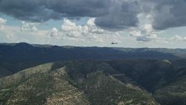 5.5K aerial stock footage zooming in on a Cessna over desert mountains, partly cloudy day, Carbon County, Utah Aerial Stock Footage | AX140_025E