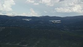 5.5K aerial stock footage of tracking Tecnam P2006T from behind Cessna flying by mountains, Wasatch Range, Utah Aerial Stock Footage | AX140_050E