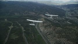 5.5K aerial stock footage of a Tecnam P2006T leading a Cessna over mountains and Highway 6, Wasatch Range, Utah Aerial Stock Footage | AX140_063E