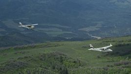 5.5K aerial stock footage of tracking Tecnam P2006T and Cessna aircraft over mountains and trees, Wasatch Range, Utah Aerial Stock Footage | AX140_087E