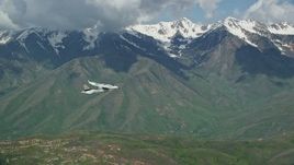 5.5K aerial stock footage of tracking a Tecnam P2006T near snowy mountain peak, Wasatch Range, Utah Aerial Stock Footage | AX140_122E