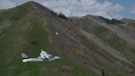 5.5K aerial stock footage of a Tecnam P2006T passing a green mountain, aspen trees, snow patches, Wasatch Range, Utah Aerial Stock Footage | AX140_140