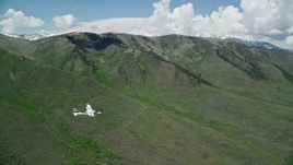 5.5K aerial stock footage of a Tecnam P2006T flying by green mountains, Wasatch Range, Utah Aerial Stock Footage | AX140_154