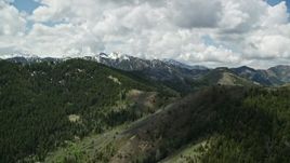 5.5K aerial stock footage of a wide view of green mountains and distant snowy peaks in the Wasatch Range, Utah Aerial Stock Footage | AX140_229E