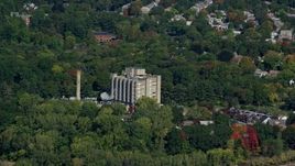 5.5K aerial stock footage flying by factory and smoke stack, trees in autumn, Hyde Park, Massachusetts Aerial Stock Footage | AX142_012