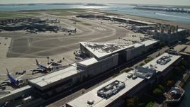 5.5K aerial stock footage flying by parked planes, Logan International Airport, Boston, Massachusetts Aerial Stock Footage | AX142_033