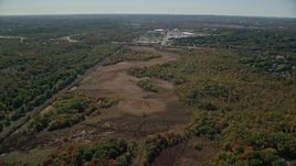 5.5K aerial stock footage flying over forest, approach warehouse buildings, autumn, Dedham, Massachusetts Aerial Stock Footage | AX142_322