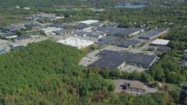 5.5K aerial stock footage flying over forest, approach warehouse buildings, autumn, Braintree, Massachusetts Aerial Stock Footage | AX143_006