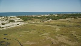 5.5K aerial stock footage flying over marshland, by isolated homes, coastal road, Barnstable, Massachusetts Aerial Stock Footage | AX143_136E