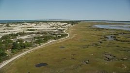5.5K aerial stock footage flying over coastal road, marshland, sand dunes, Barnstable, Massachusetts Aerial Stock Footage | AX143_138E